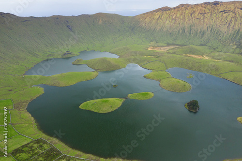 Aerial view of volcanic crater (Caldeirao) with a beautiful lake on the top of Corvo island. Azores islands, Portugal.