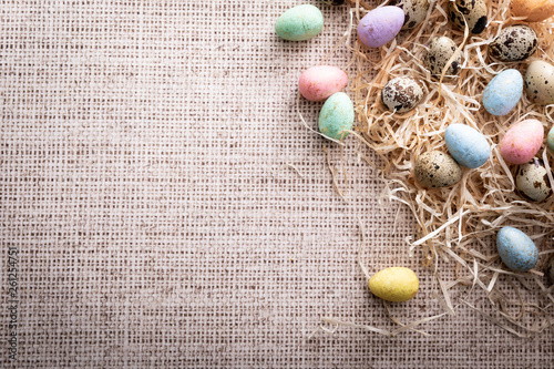 Easter, colorful quail eggs on a linen background.