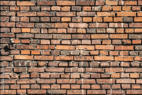 A beautiful horizontal texture of part of a old crashed brick wall in brown hue