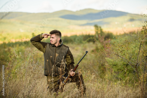 Bearded hunter spend leisure hunting. Hunter hold rifle. Focus and concentration of experienced hunter. Hunting and trapping seasons. Man brutal gamekeeper nature background. Hunting permit