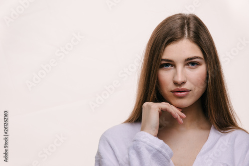 Beauty Spa Woman with perfect skin Portrait. Beautiful Brunette Spa Proposing a product. Gestures for advertisement. Beige background © Tetiana Moish