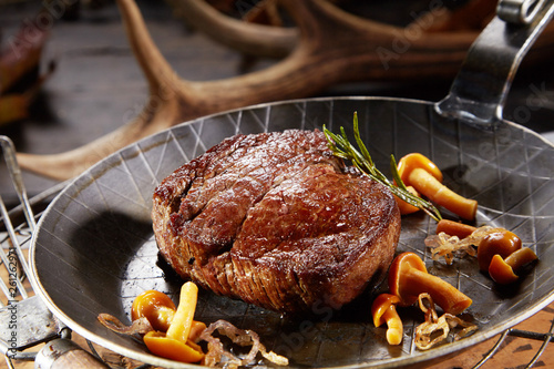 Marinated wild venison deer steak with mushrooms