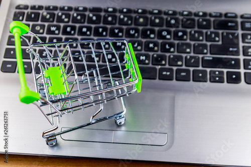 Online shopping concept. Small shopping cart on laptop keyboard