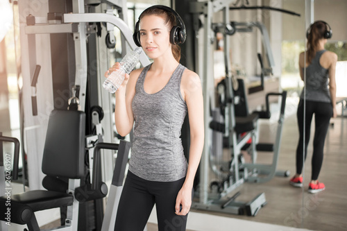 Pretty young sport woman is drinking water  in gym, Healthy lifestyle