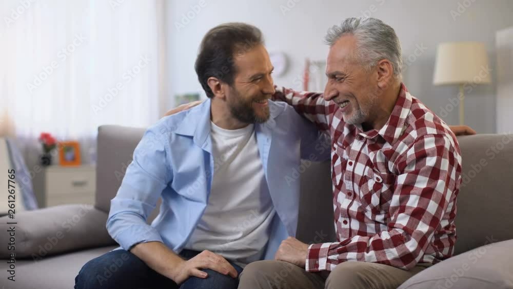 Aging father and middle aged son punching fists friendly family relations, trust Aging father and middle aged son punching fists friendly family relations, trust