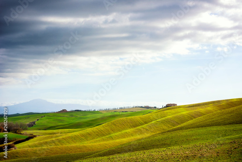 Tuscan hill with row of cypress trees and farmhouse ruin at sunset. Tuscan landscape. Italy