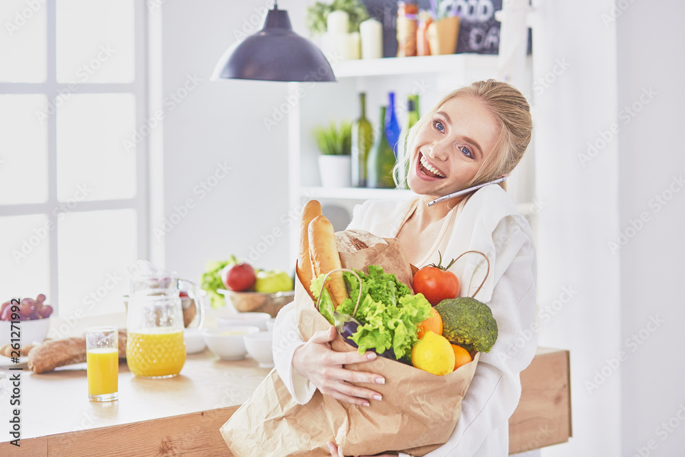 Young woman holding grocery shopping bag with vegetables Standi