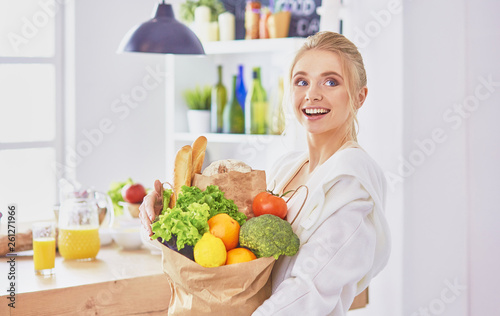 Young woman holding grocery shopping bag with vegetables Standi