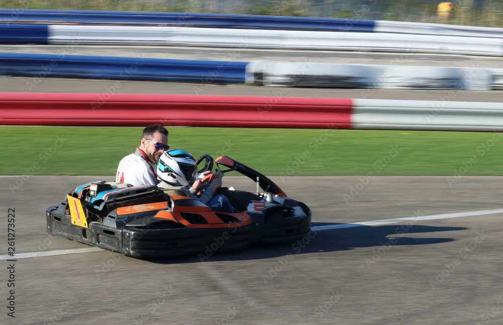 padre e hijo en un kart biplaza en un circuito de carreras