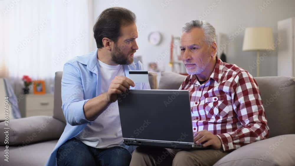 Middle aged male showing how to make payments through internet, online security Middle aged male showing how to make payments through internet, online security