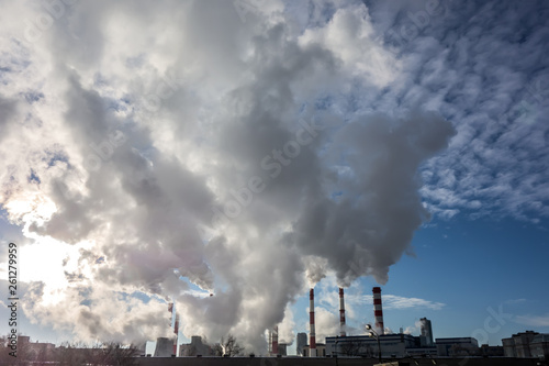 Steaming smoke stack and cooling tower with pollution