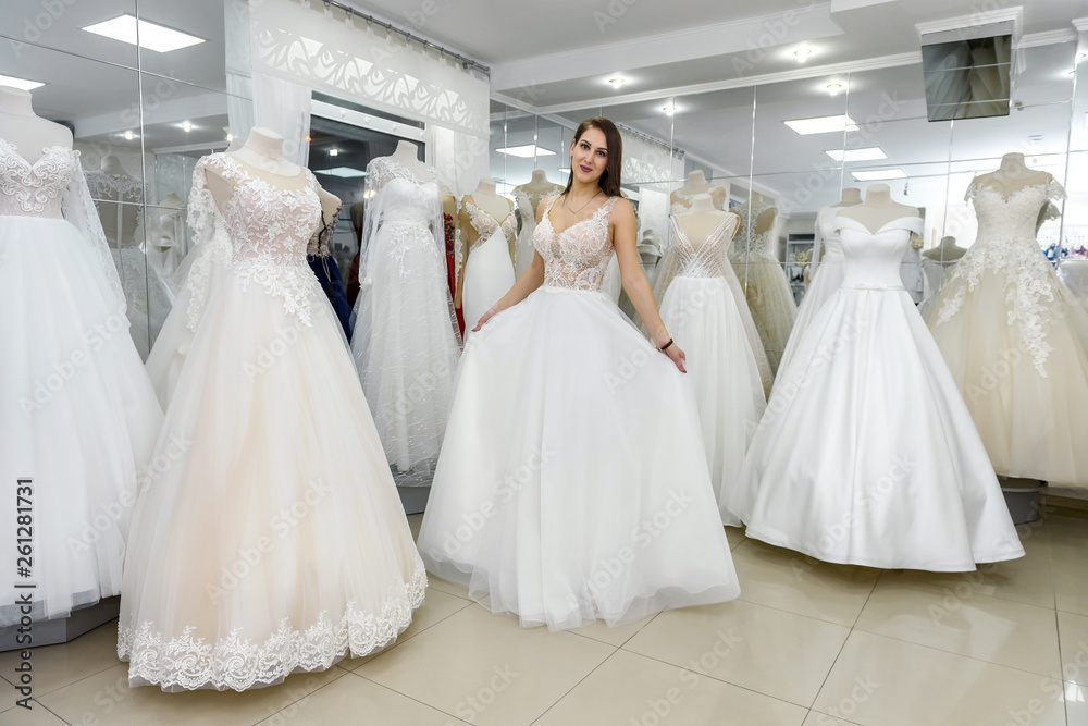 Bride in wedding dress fitting it in atelier