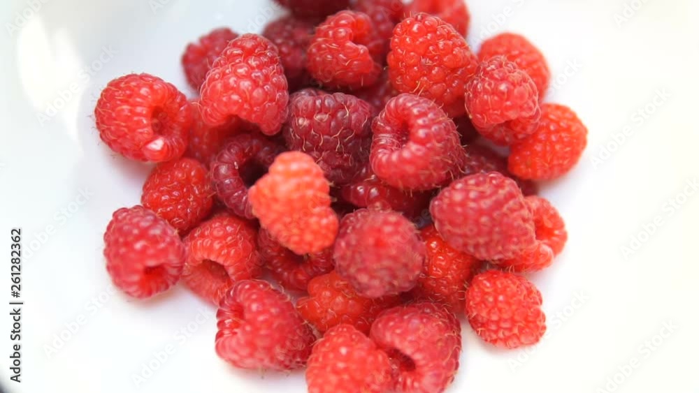 Heap of raspberries are rotated on the on the turntable isolated on the white background. Close up. Heap of raspberries are rotated on the on the turntable isolated on the white background. Close up.