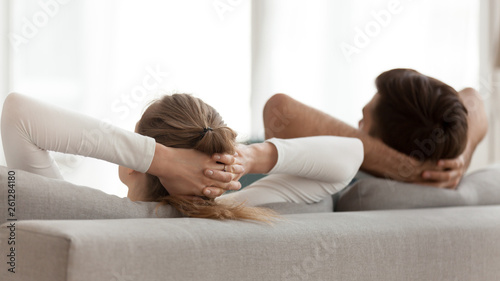 Rear view peaceful young couple relaxing on sofa together