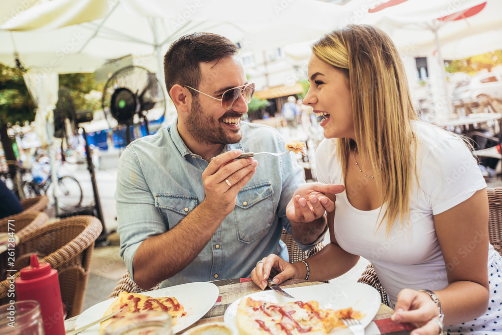 Couple eating pizza snack outdoors.They are sharing pizza and eating. Couple eating pizza snack outdoors.They are sharing pizza and eating.