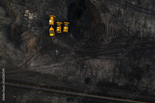 Top down view on yellow excavators in coal storage.
