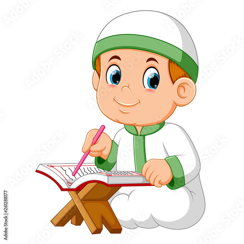 the boy is sitting and reading al quran 
