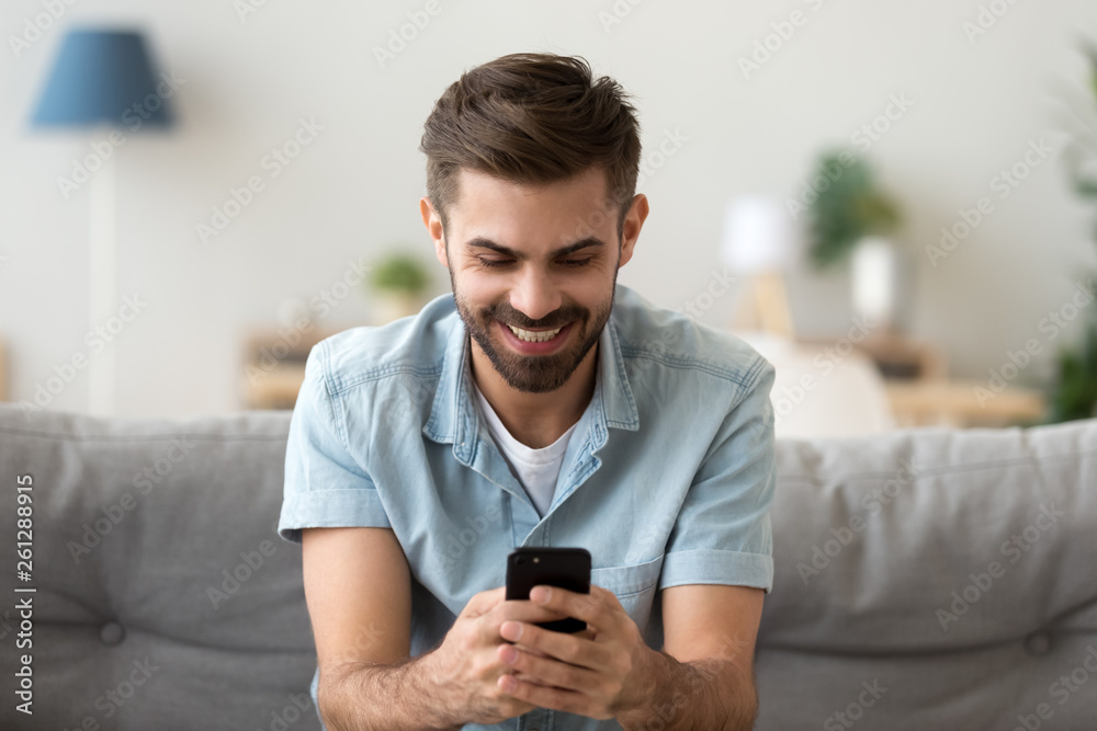 Excited smiling man looking at phone screen, using mobile app Excited smiling man looking at phone screen, using mobile app
