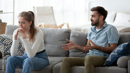 Angry man lecturing unhappy upset crying woman at home