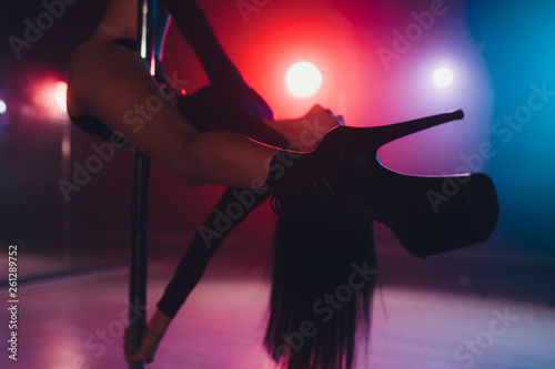 Foto young striptease dancer moving in high heels shoes on stage in strip night club, Pole dancing