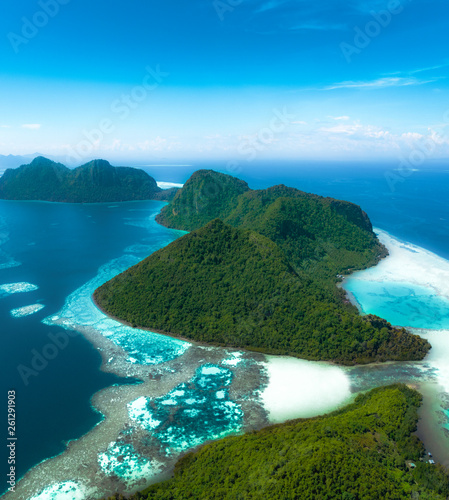 Amazing tropical paradise islands from the air with blue turquoise blue lagoon water and coral reef. Aerial view of Bohey Dulang island panorama. Hawaii, Philippines, French polynesia.
