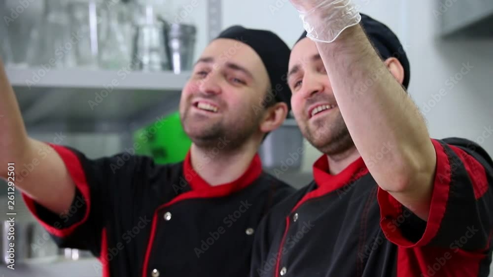 Restaurant kitchen. Two men chefs finished serving dishes with a bellissimo gesture