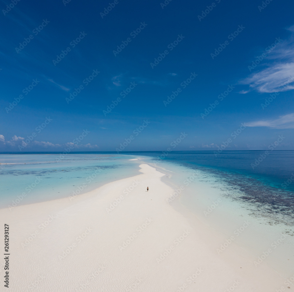Aerial view of a man walking on the white sand bar in the tropical destination. Hawaii French polynesia Maledives Philippines. Aerial view of a man walking on the white sand bar in the tropical destination. Hawaii French polynesia Maledives Philippines.