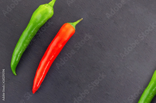 two vegetables couple of hot peppers thin pods peppers red green chili part frame on a black background copy space