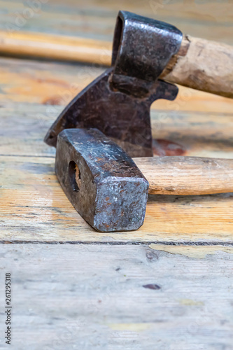 folded tools sledgehammer ax black old weathered on wooden base close-up