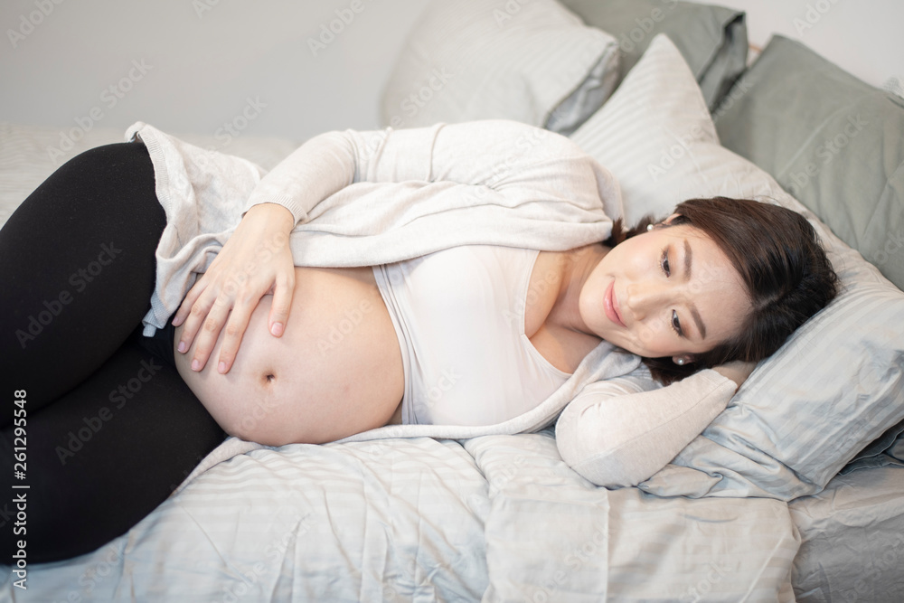 Beautiful asian pregnant woman is sleeping on bed
