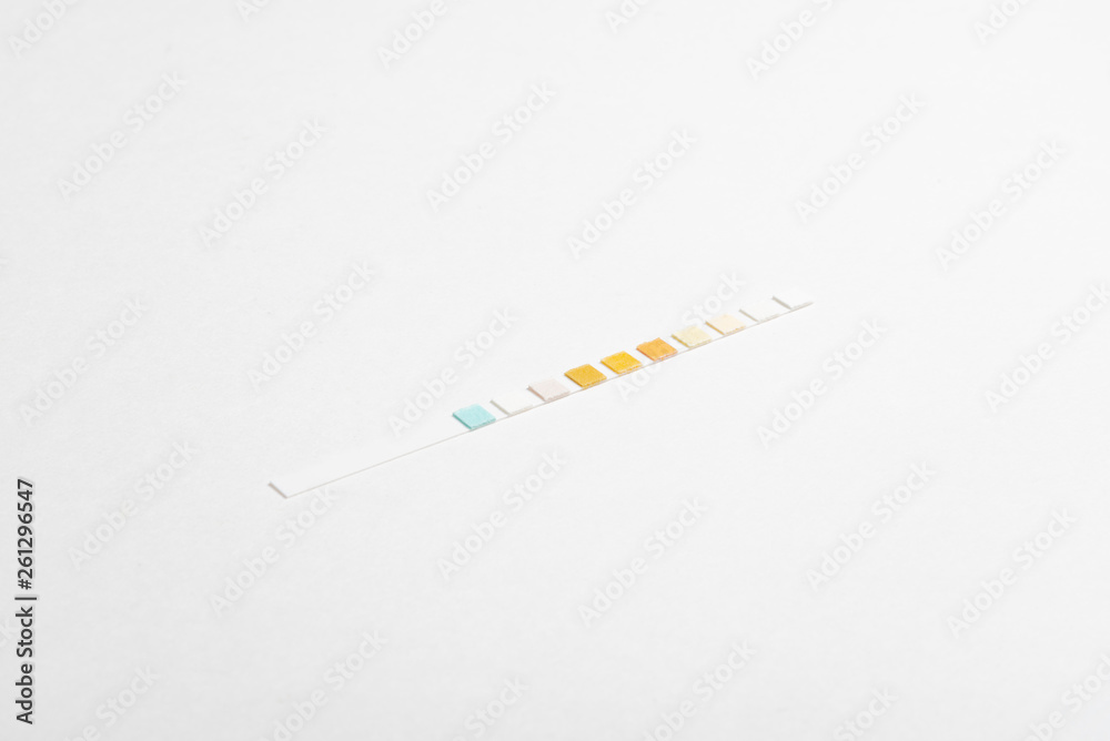 Obraz premium A single unused urine reagent strip for medical testing set on a plain white background.