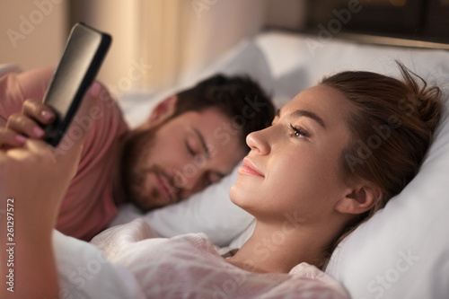 Fotografija technology, internet addiction and cheat concept - woman using smartphone at nig