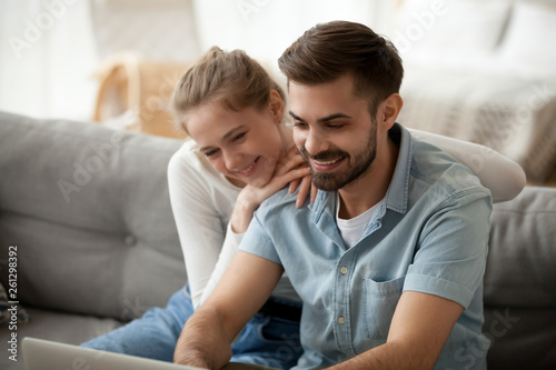 Happy couple spending time together at home, using laptop