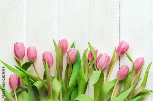 Spring flower. Bunch of Pink tulips place on white wooden background. Selective focus.