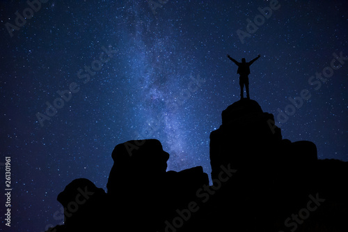 Night sky and man on peak of rock