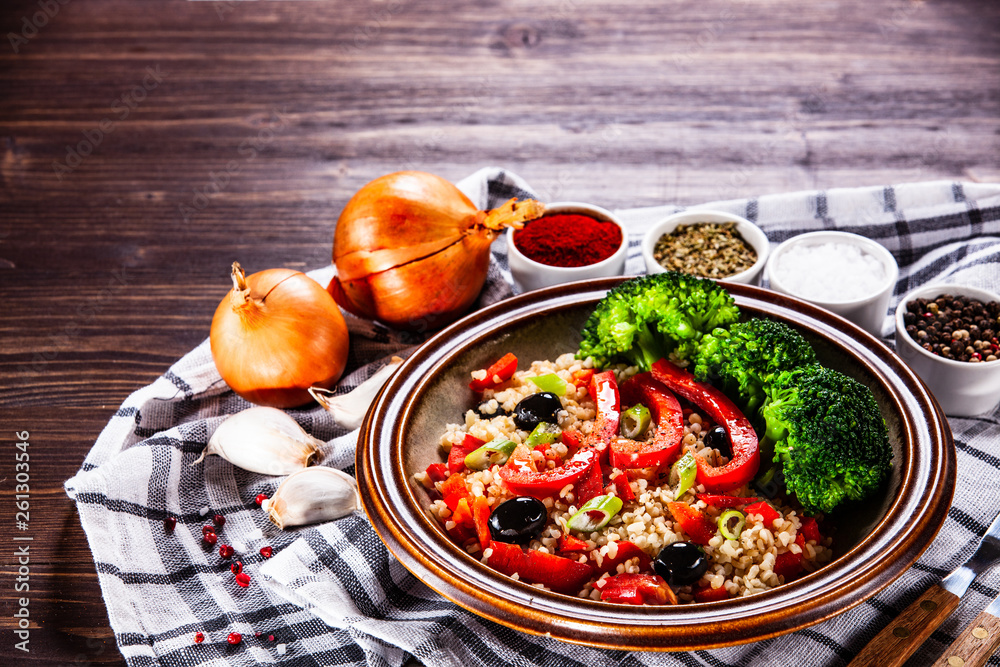 Groats with vegetables on wooden table Groats with vegetables on wooden table