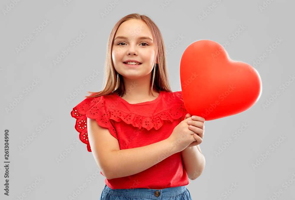 childhood and people concept - smiling girl with red heart shaped balloon over grey background childhood and people concept - smiling girl with red heart shaped balloon over grey background