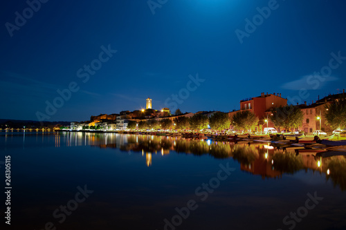 Panorama notturno di Marta VT, Italia che si riflette sulle acque del Lago di Bolsena.