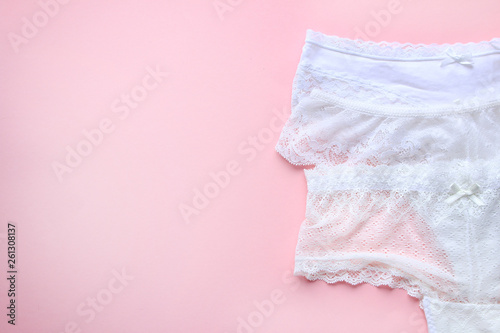Set of white sexy lace women's panties on pink background. Top view. Close up.