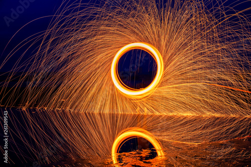 Light painting. Pyrotechnic display at night with the reflection of the water