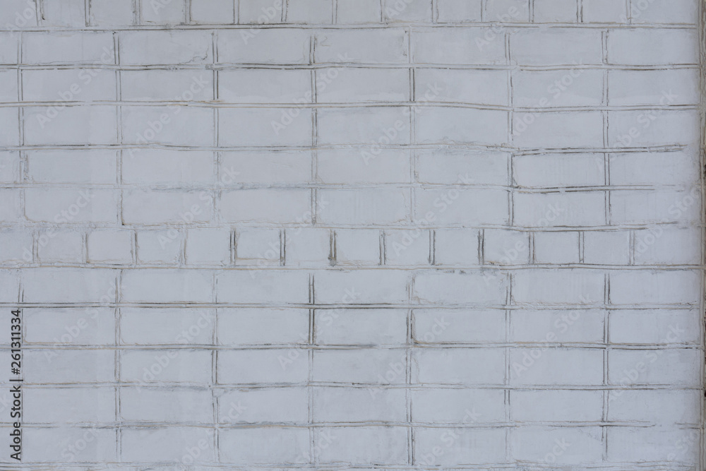 Naklejka premium An old brick uneven wall painted unevenly white. Best for backgrounds