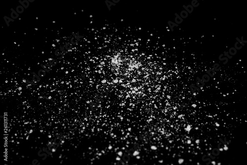 white crystalline powder on a black background. sugar dust 