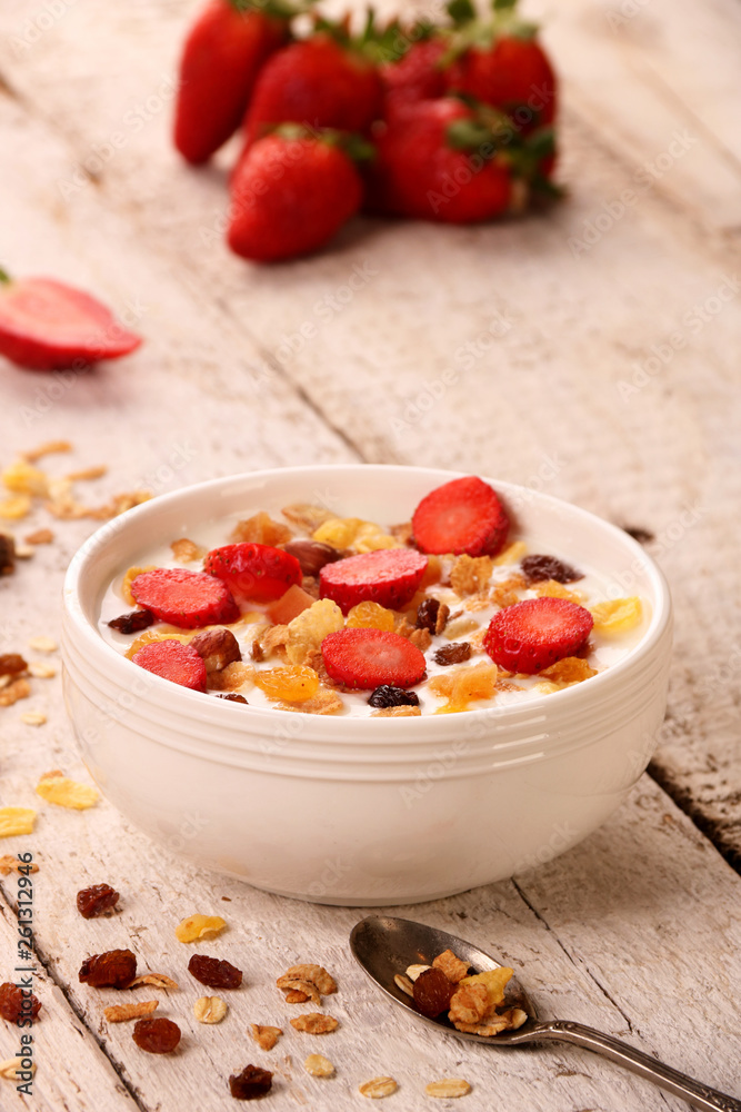 Bowl of yogurt with strawberries and granola muesli, over a white wood background. Bowl of yogurt with strawberries and granola muesli, over a white wood background.