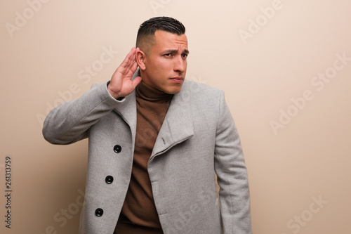 Young latin business man try to listening a gossip