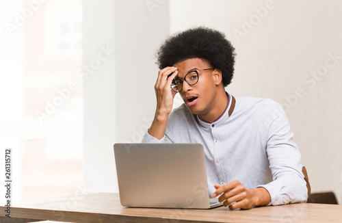 Young black man using his laptop worried and overwhelmed