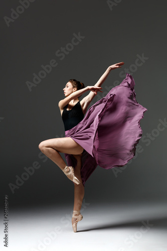 Young beautiful ballerina is posing in studio