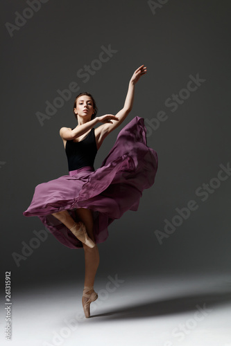 Young beautiful ballerina is posing in studio