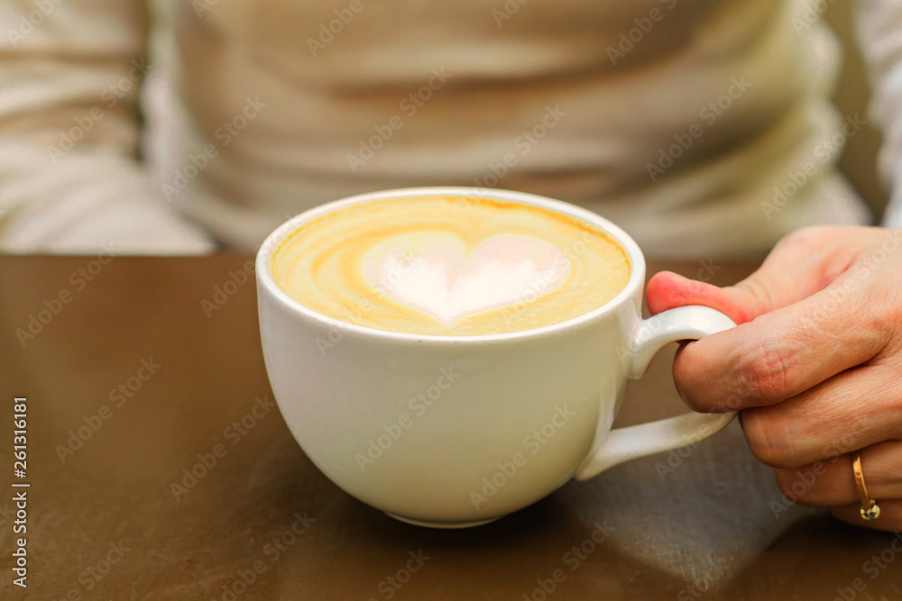 Fototapeta close up of big cup of freshly brewed cappuccino with soft foam and brown sugar and drawing heart by barista