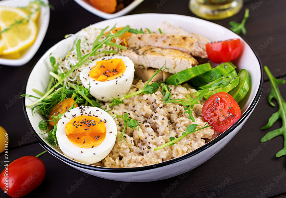 Fresh salad. Breakfast bowl with oatmeal, chicken fillet, tomato, lettuce, microgreens and boiled egg. Healthy food. Vegetarian buddha bowl. Fresh salad. Breakfast bowl with oatmeal, chicken fillet, tomato, lettuce, microgreens and boiled egg. Healthy food. Vegetarian buddha bowl.