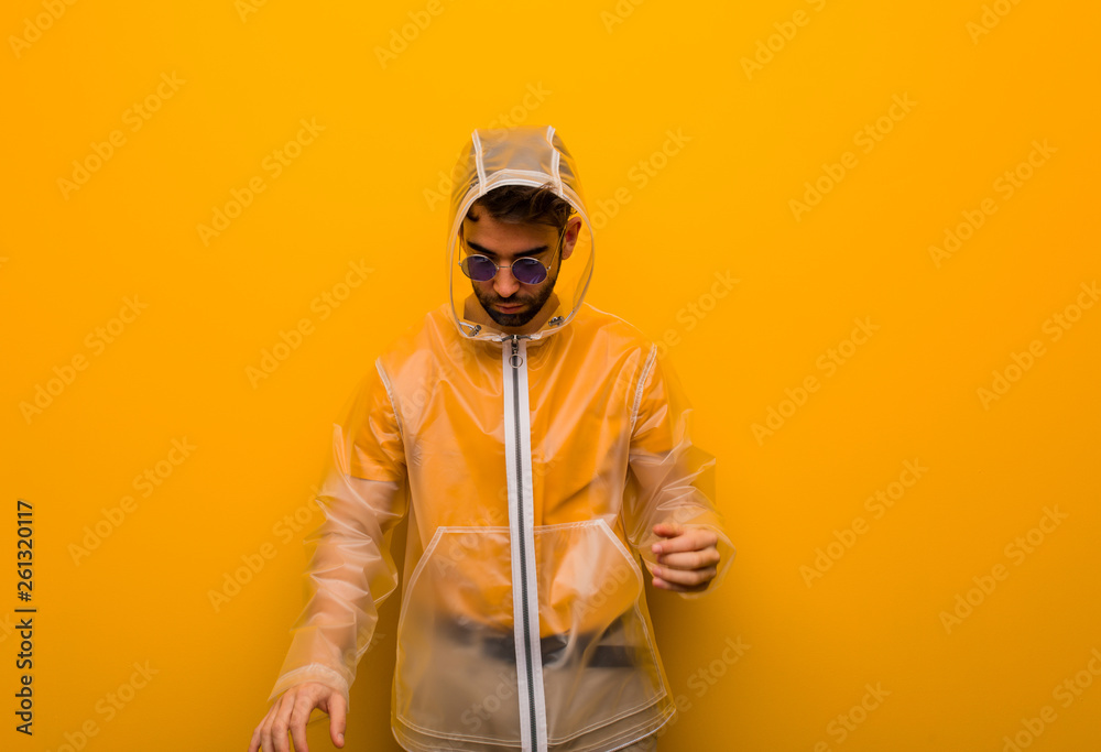 Young man wearing a rain coat tired and very sleepy